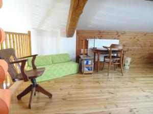 a living room with a green couch and a table at La Bruyère aux Lamas in Saint-André-dʼApchon