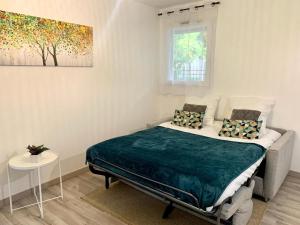 ein Schlafzimmer mit einem Bett und einem Gemälde an der Wand in der Unterkunft Sweet home disneyland in Montévrain