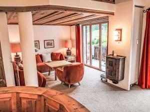 Una sala de estar con un sofá y una estufa. en Apartment Villa Waldpark by Interhome, en Flims