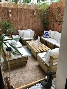 a patio with couches and tables and a fence at Chambre avec terrasse chez l'habitant dans appartement moderne in Neuilly-sur-Seine +5 photos