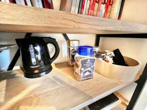 a shelf with a coffee maker and a tea kettle at Chambre avec terrasse chez l'habitant dans appartement moderne in Neuilly-sur-Seine
