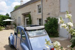 een kleine blauwe auto geparkeerd voor een huis bij Gîte La Maison De Lucien in Meursault