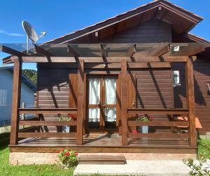 卡内拉Suite 391 - Quarto privativo em casa的小木屋设有大型甲板