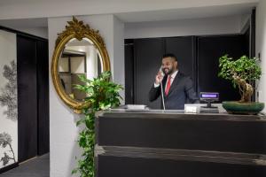 mężczyzna w garniturze rozmawiający przez komórkę w obiekcie Coronari Palace w Rzymie