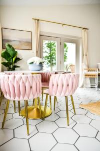 a dining room with pink chairs and a table at The Bidwell Bungalow in Amanda