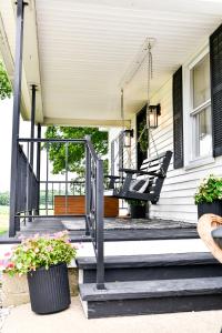 a porch with a swing on a house at The Bidwell Bungalow in Amanda