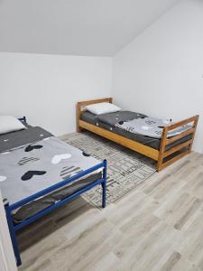 a bedroom with two beds and a wooden floor at Vikendica Dar in Begeč +30 photos