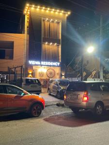 a group of cars parked in a parking lot at night at Viswa Residency Srirangam - Heritage Rooms in Tiruchirappalli