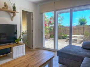 a living room with a couch and a sliding glass door at El Rincón de Deveses in Denia