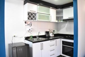 a kitchen with white cabinets and a sink at Reservas San Luis Apto 501 Cúcuta in Cúcuta