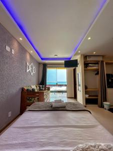 a bedroom with a large bed with a purple ceiling at Varandas ao mar loft 302 Praia Grande in Arraial do Cabo