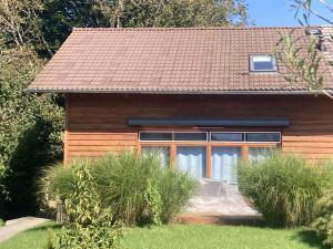 a small house with a brown roof at Tu Casa Chiemsee Ferienhaus in Gstadt am Chiemsee