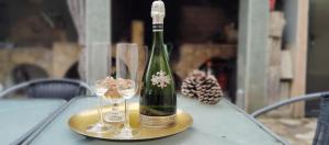 a bottle of wine sitting on a table with two wine glasses at casa rural El Burrillo in Cuenca
