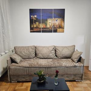 a living room with a couch and a picture on the wall at ONLY 4 YOU apartment in Niš
