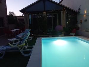 a swimming pool with two chairs and a house at casa rural El Burrillo in Cuenca