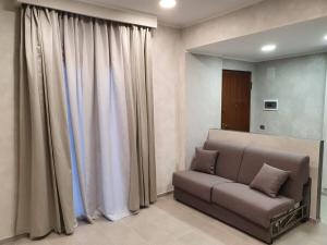 a living room with a couch and curtains at B&B FLOWER 2 in Cornaredo