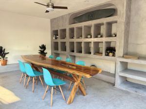 a dining room with a wooden table and blue chairs at Casa Kâi in Brisas de Zicatela