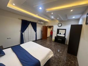 a bedroom with a bed and a clock on the wall at خزامى ابها للشقق المخدومة in Abha +52 photos