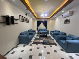 a waiting room with blue couches and a stage at خزامى ابها للشقق المخدومة in Abha