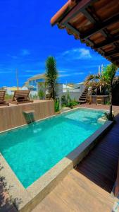 a swimming pool with blue water in a house at POUSADA ONDA CARIOCA in Cabo Frio