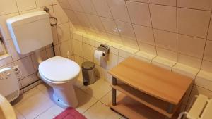 a bathroom with a toilet and a wooden table at gemütliches Waldhaus in Milmersdorf +7 photos