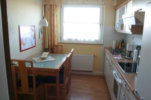 a kitchen with a table and chairs and a window at Ferienwohnung Illerhues in Ascheberg