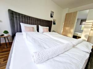 a large bed with white sheets and pink pillows at Infinity Apartment & Free Wifi & Free Parking in Sarajevo