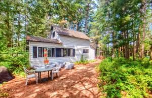 une cabine dans les bois avec une table et des chaises dans l'établissement Grant Island Waterfront Cottage Brantingham Lk - HotTub, Pontoon Boat, Pets, à Glenfield