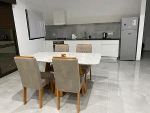 a kitchen with a table and chairs and a refrigerator at Casa Nelly & Toi JB in Tarrafal
