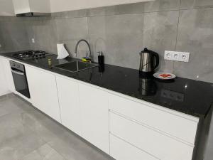 a kitchen with a black counter top and a stove at Casa Nelly & Toi JB in Tarrafal +2 photos