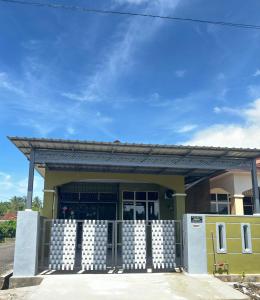 a yellow building with a gate in front of it at K'Lia Homestay Merbok in Kampong Merbok +8 photos