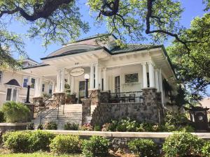 a large white house with a porch and stairs at Canal Street Inn in New Orleans