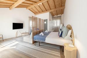 a bedroom with a large bed and a tv at Surf & Chill Peniche Villa in Atouguia da Baleia