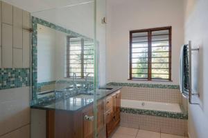 a bathroom with a sink and a mirror and a tub at Paradise Hideaway in Knysna +16 photos