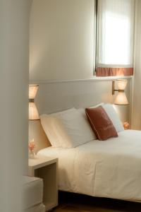 a bedroom with a white bed with two lamps at Sorapiana in Vidor