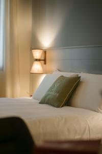 a bed with a green pillow and a lamp at Sorapiana in Vidor
