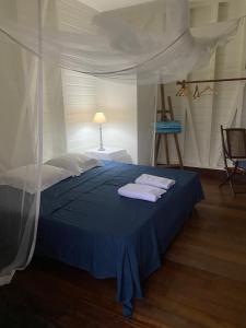 a bedroom with a bed with two towels on it at villa Kabri terre de bas in Terre-de-Bas