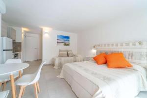 Un dormitorio blanco con una cama grande y una mesa. en La Stampa Home, en Olbia
