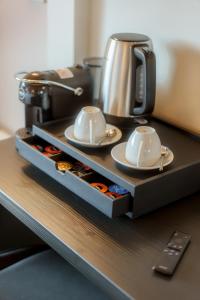a coffee maker and two cups on a table at Sorapiana in Vidor