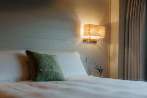 a bed with a green pillow on top of it at Sorapiana in Vidor