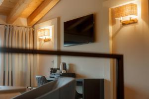 a living room with a desk and a television on the wall at Sorapiana in Vidor