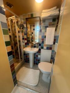 un baño con inodoro y lavabo en Addison B&B, en Guildford 12 fotos más