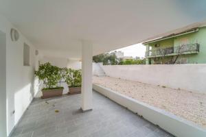 Un patio vacío de un edificio blanco con plantas en macetas. en La Stampa Home, en Olbia