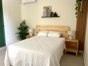 a bedroom with a bed with a wooden headboard at Hotel Rimani in San Salvador