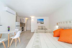 Sala de estar blanca con mesa y cama en La Stampa Home, en Olbia