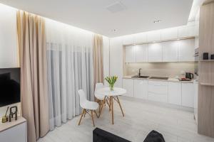 a kitchen with white cabinets and a table and chairs at MIA Centrum Wrocław in Wrocław