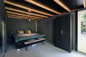 Un dormitorio con una cama y un techo de madera. en Luxury of Nature - boutique, en Helvoirt