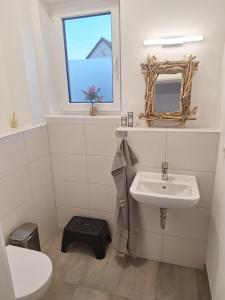 a bathroom with a sink and a toilet and a window at Ferienhaus Lutki - Neues Familiendomiziel im Spreewald - Ideal für Hundehalter in Lübbenau +10 photos