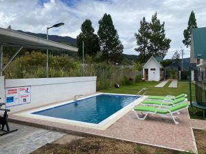 a swimming pool with a chair and a chair at Hahn des Felsens in Oxapampa