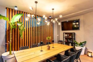 a dining room with a wooden table and some plants at Rab Rental Villa in Rab